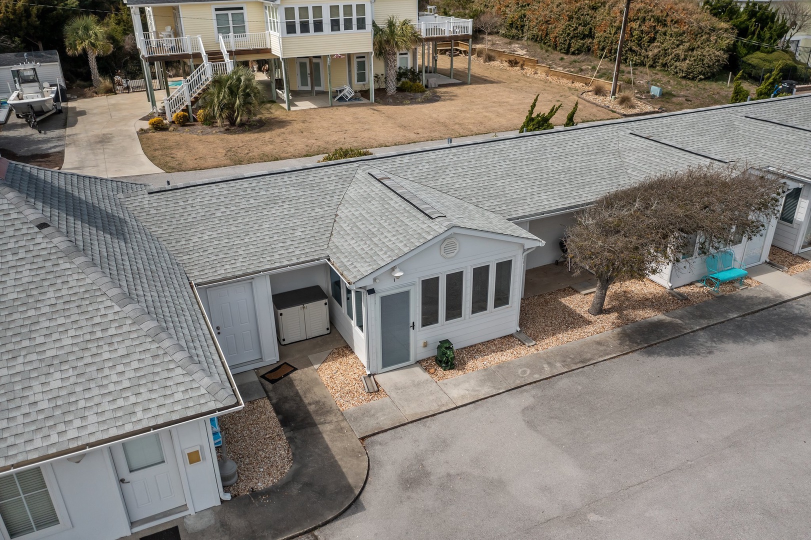 Aerial view of charming beachside properties in a peaceful coastal neighborhood, showcasing the property's prime location near the shore.