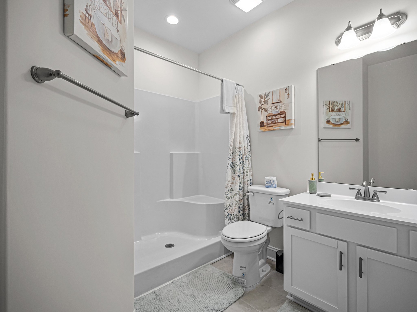 Refresh in your bright, clean bathroom featuring a spacious shower and modern vanity with thoughtful touches.