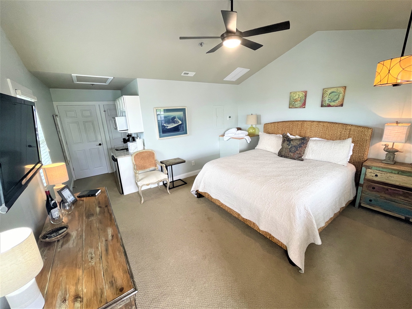 Sink into coastal comfort in your stylish bedroom, where crisp white linens and warm wicker accents create the perfect retreat after your beach adventures.