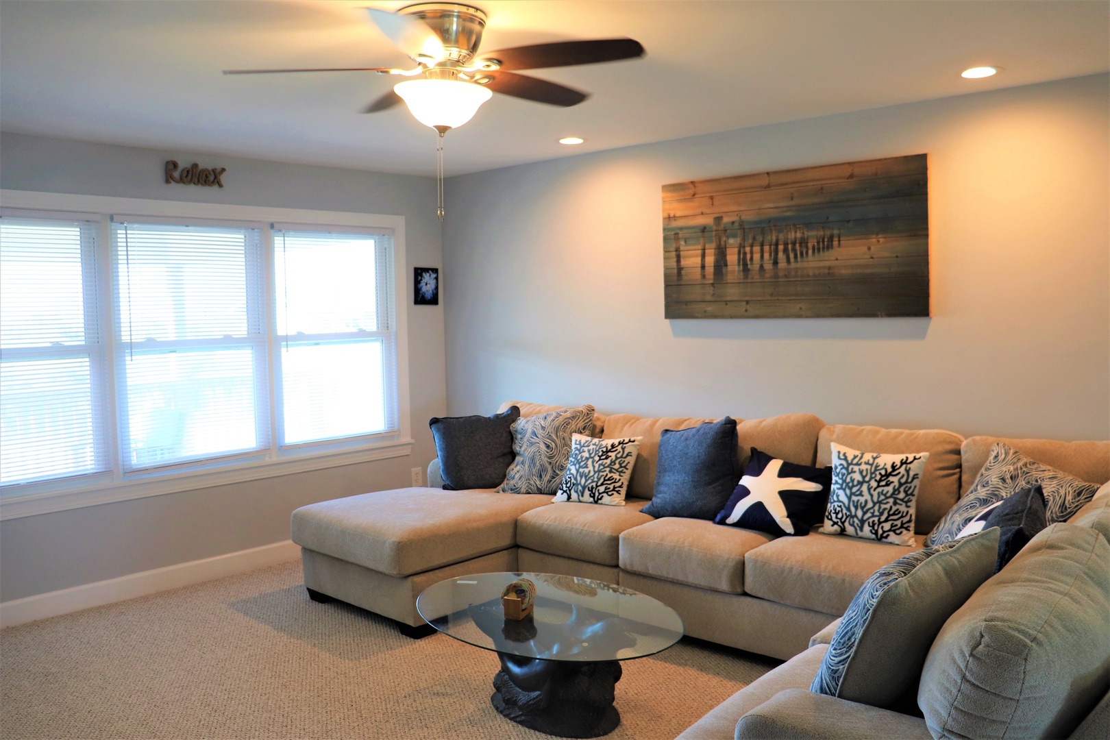 Sink into coastal comfort on your spacious sectional sofa, surrounded by nautical touches and soft ocean breezes through bright windows.