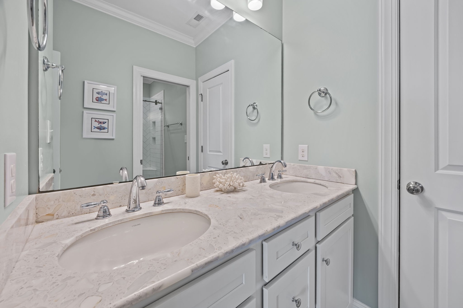 Your private bathroom features elegant marble countertops, dual sinks, and soothing coastal decor for morning routines.