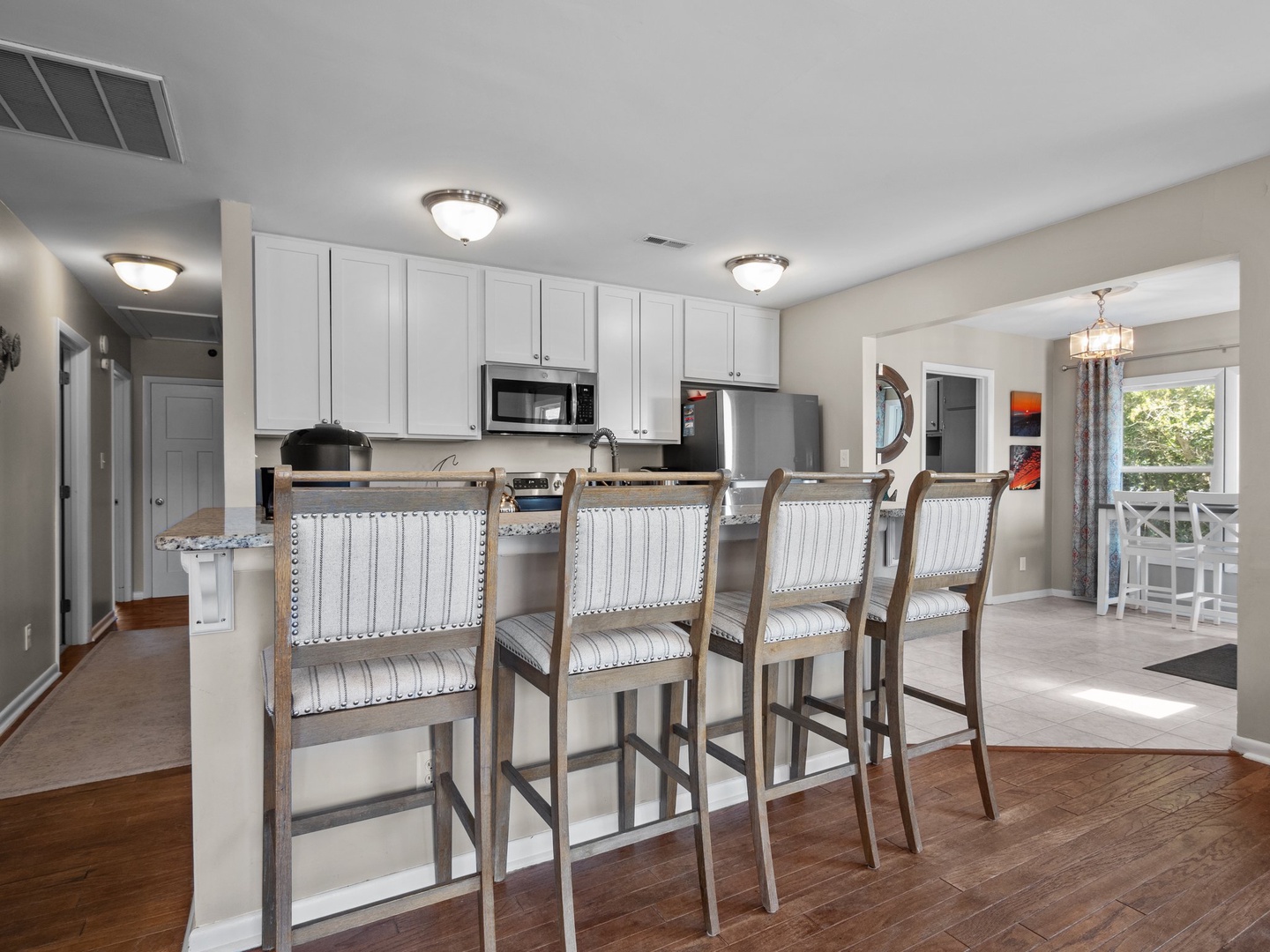 Your gourmet kitchen awaits with spacious granite counters, modern appliances, and comfortable breakfast bar seating for memorable meals together.