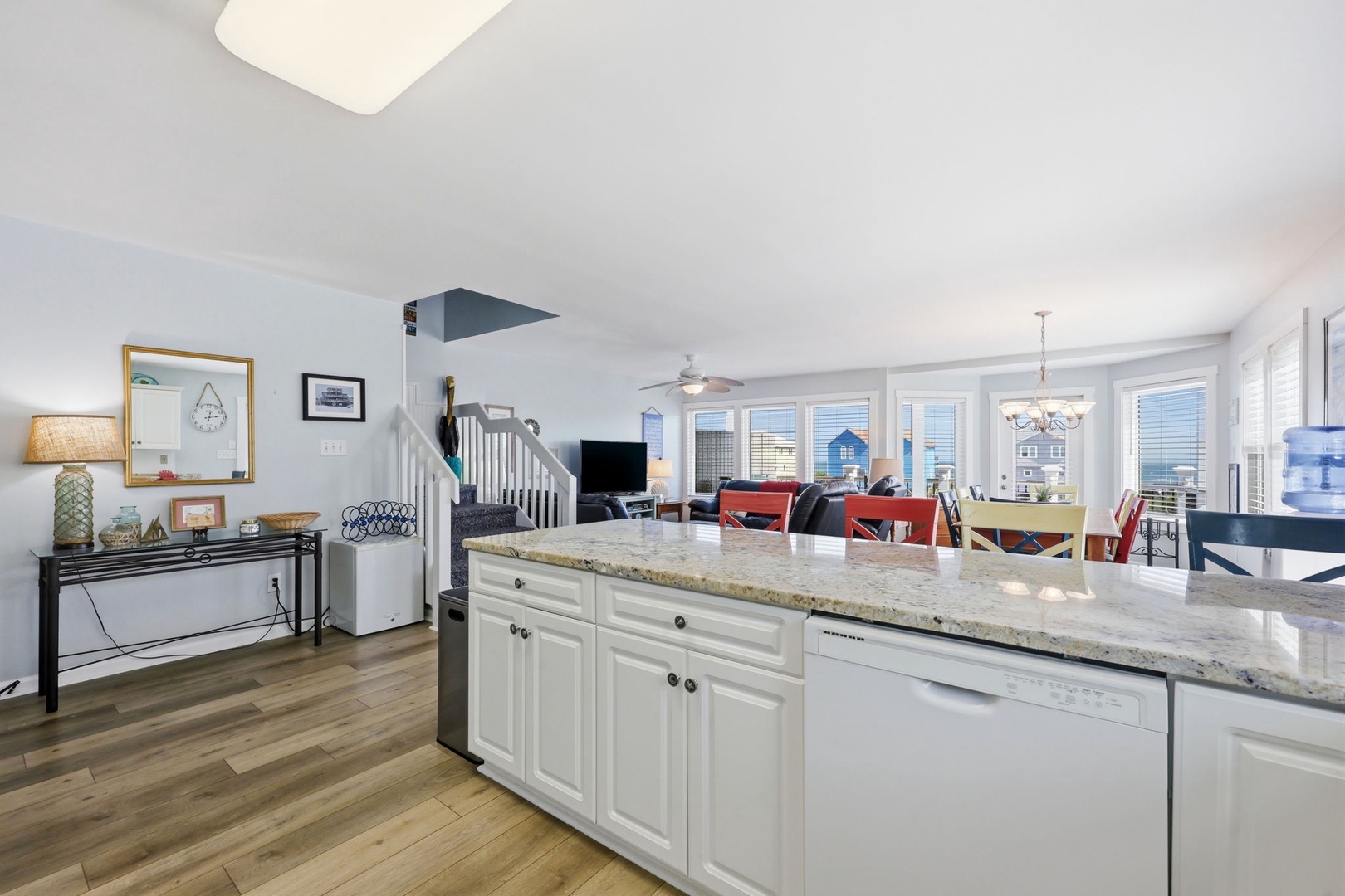 Step into your bright, open-concept living space where natural light pours through oversized windows, illuminating sleek granite countertops and elegant wood-style floors that flow seamlessly from kitchen to dining to cozy seating areas.