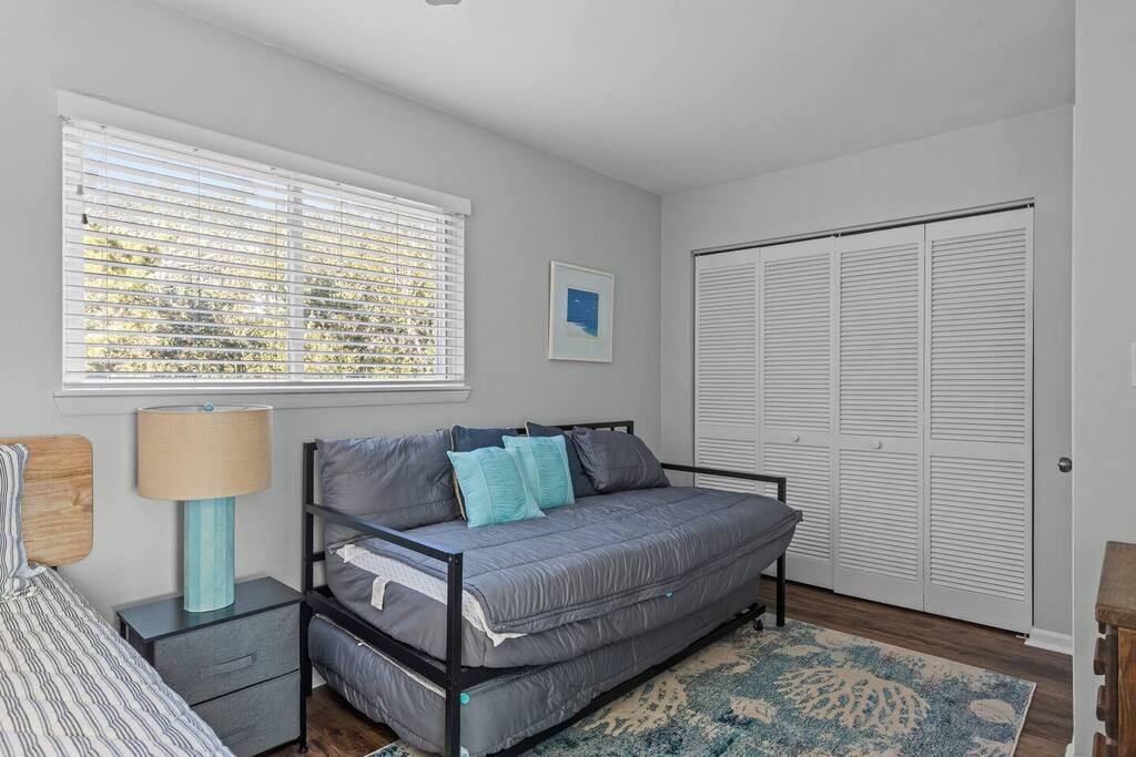 Relax in your bright bedroom featuring a comfy trundle bed and stylish teal accents.