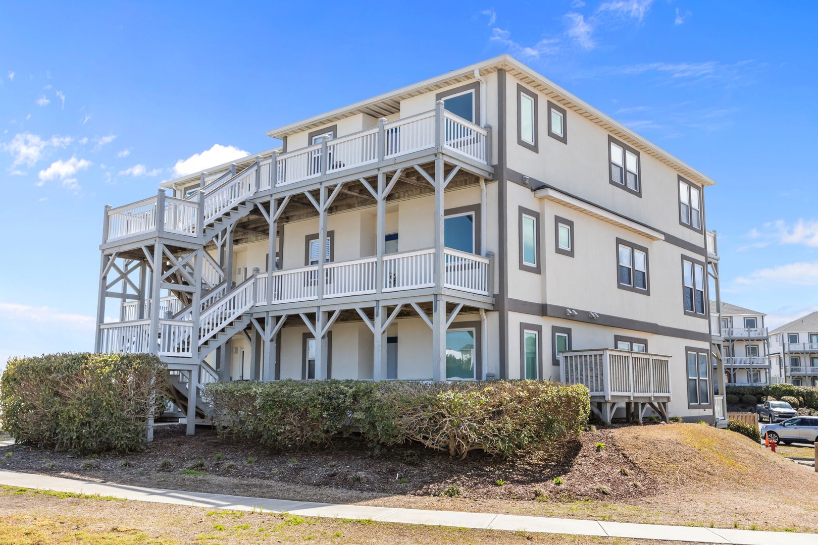 Charming beachside property with multiple balconies and coastal architecture in a peaceful residential setting.