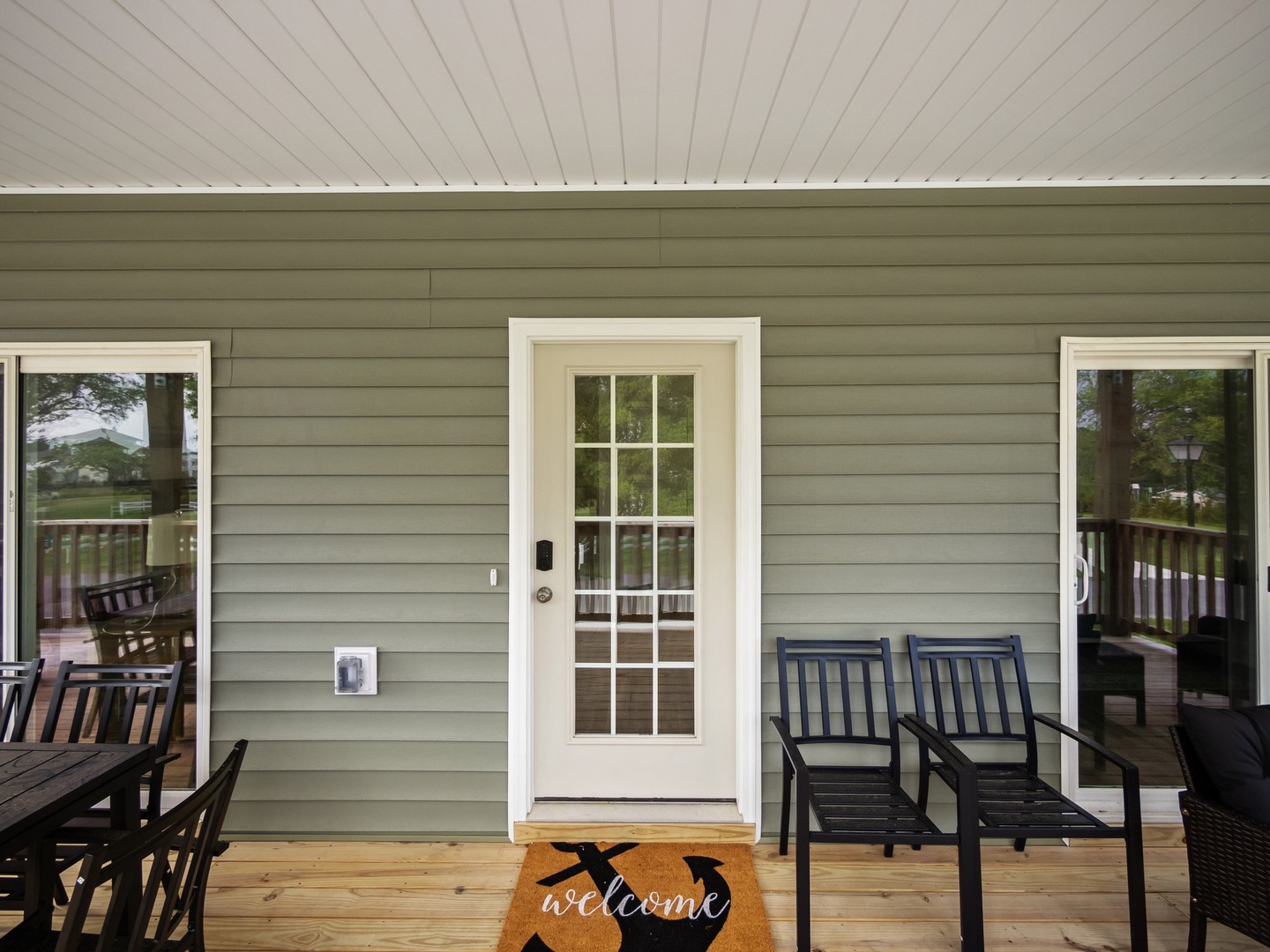 Step onto your private covered porch where comfortable seating awaits and a welcoming doormat sets the tone for your perfect getaway.