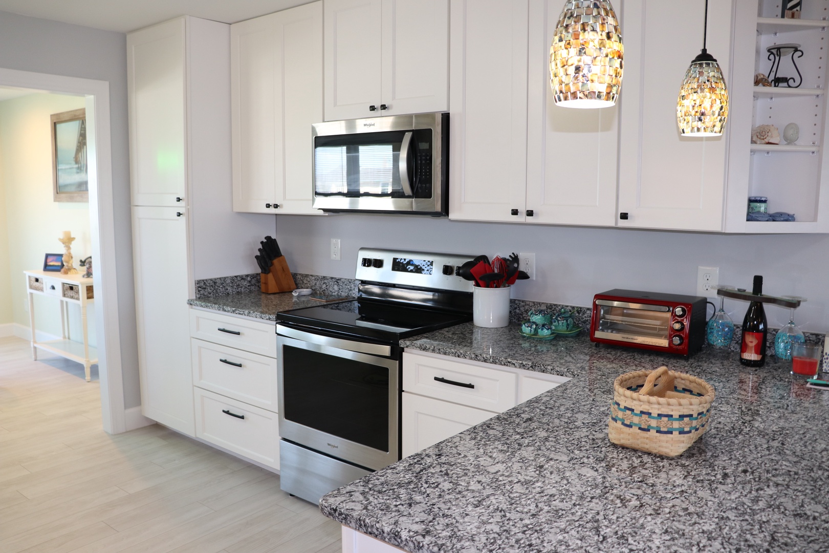 Prepare meals in your fully equipped kitchen with granite counters, modern appliances, and charming pendant lighting creating the perfect cooking atmosphere.