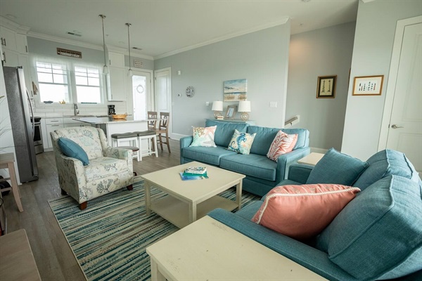 Relax in your bright coastal living room where teal sectional seating and coral accents create the perfect beachside retreat atmosphere.
