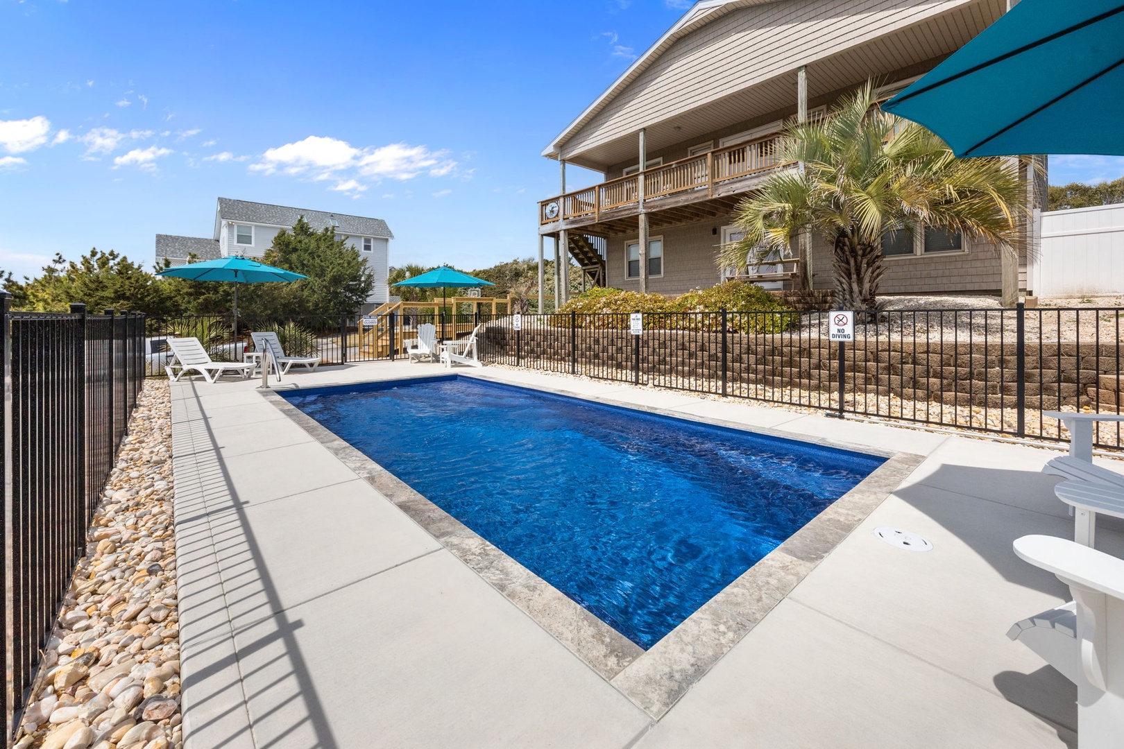 Dive into crystal-clear waters in your private pool, surrounded by comfortable loungers and tropical palms for the perfect beach getaway.