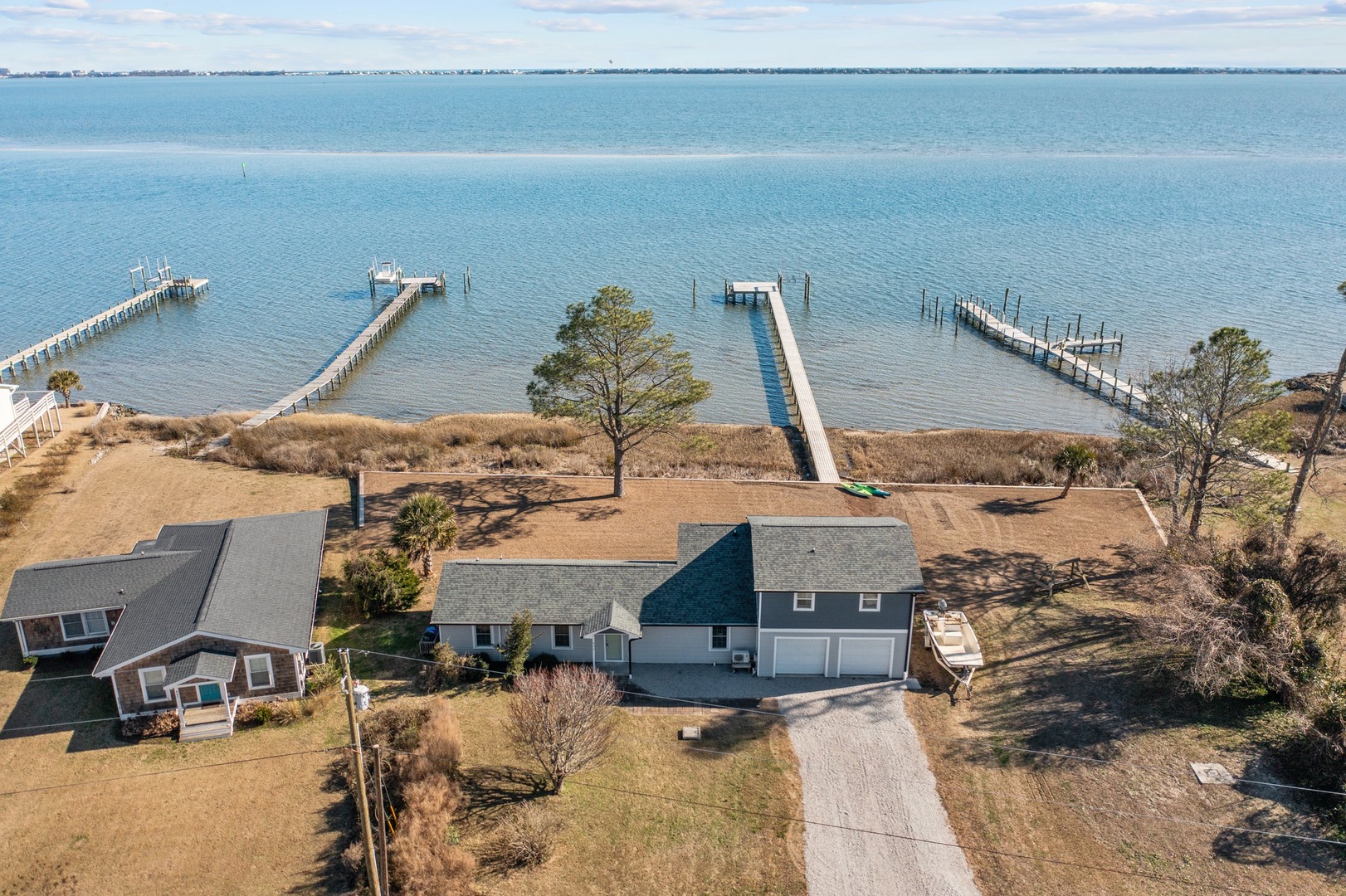 Waterfront property with private dock access to calm bay waters, surrounded by natural coastal landscape.