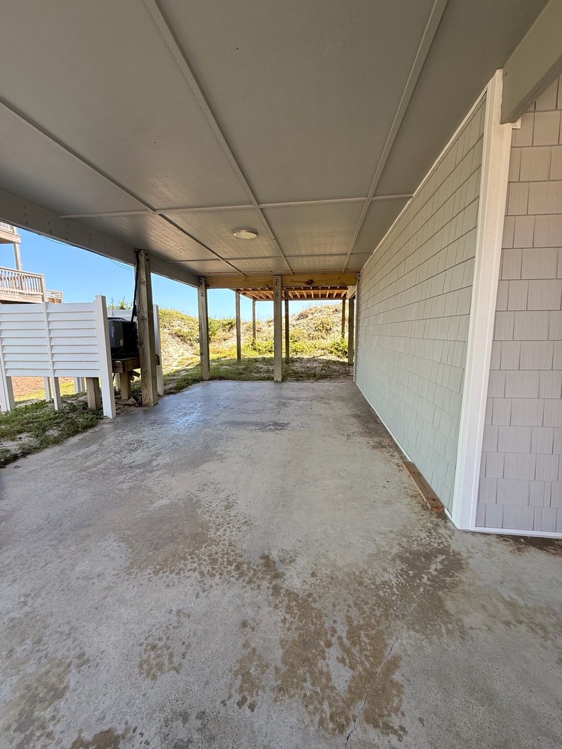 Covered parking space with natural dune and beach grass views visible beyond the property.