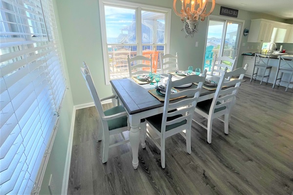 Gather your group around this bright dining space where morning coffee and evening conversations flow naturally against stunning water views.