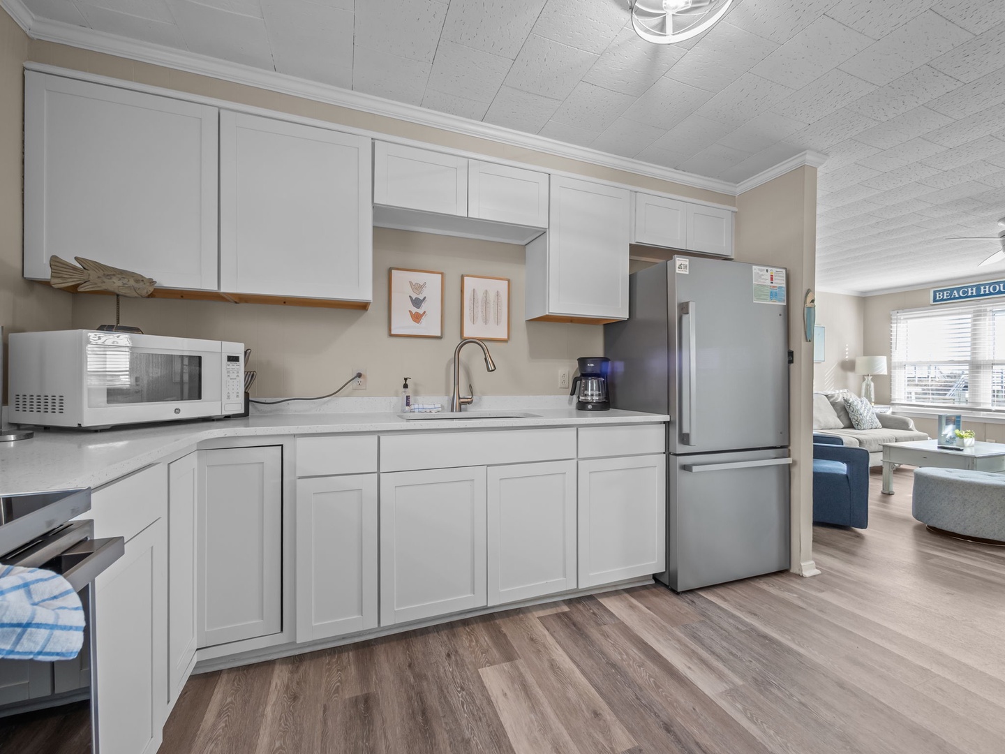 Your fully equipped kitchen awaits with crisp white cabinets, modern appliances, and coastal charm to make every meal memorable.