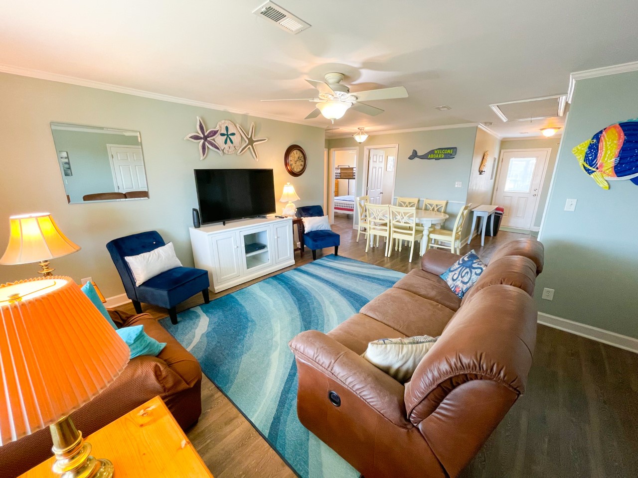 Unwind in your bright, beach-themed living space with plush recliners and coastal decor that perfectly captures the vacation spirit.