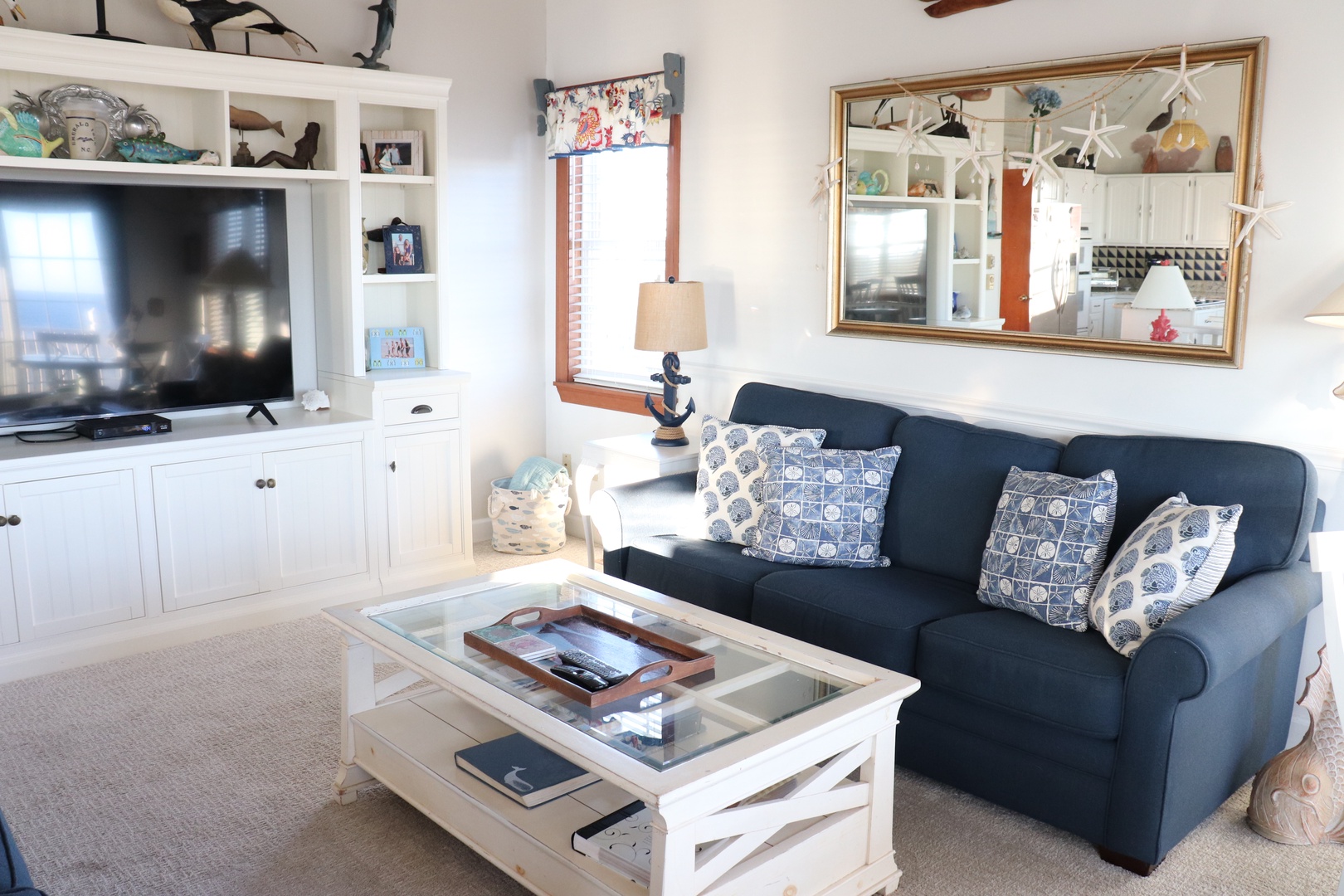 Relax in your charming coastal living room with nautical touches, plush seating, and entertainment center for cozy evenings together.