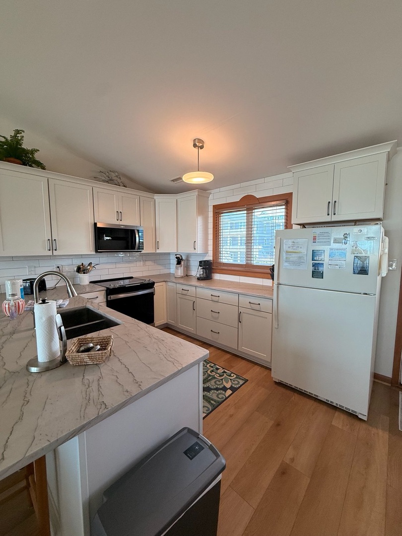 Your fully equipped kitchen features bright white cabinetry, elegant countertops, and all the modern appliances you need to feel right at home during your stay.
