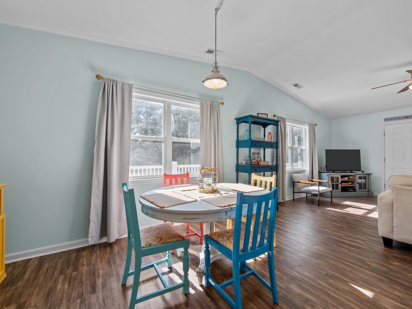 Relax in this bright, airy living space where coastal blues and warm wood floors create your perfect retreat atmosphere.