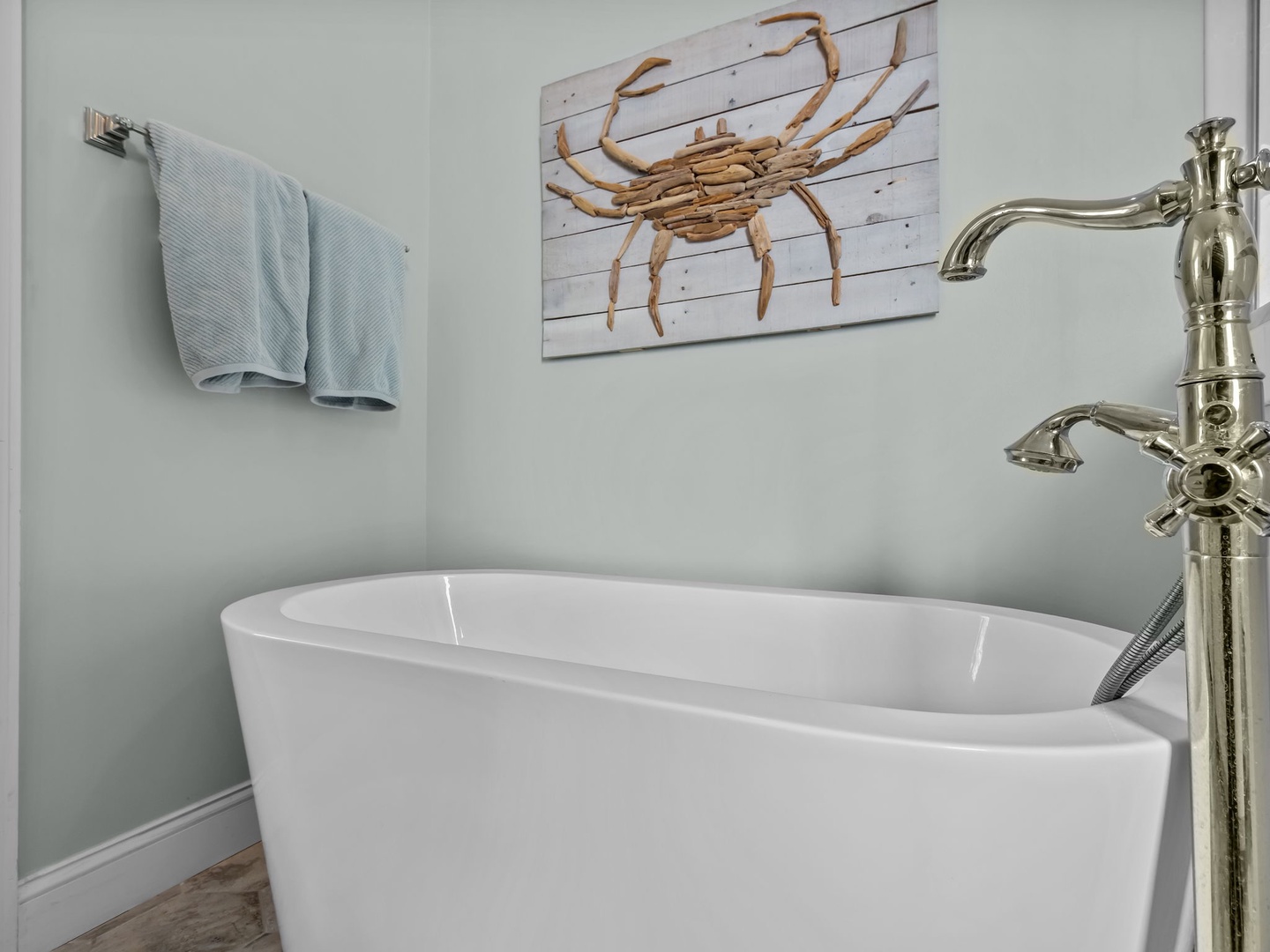 Sink into your private soaking tub with coastal charm surrounding you in soft blues and nautical decor.