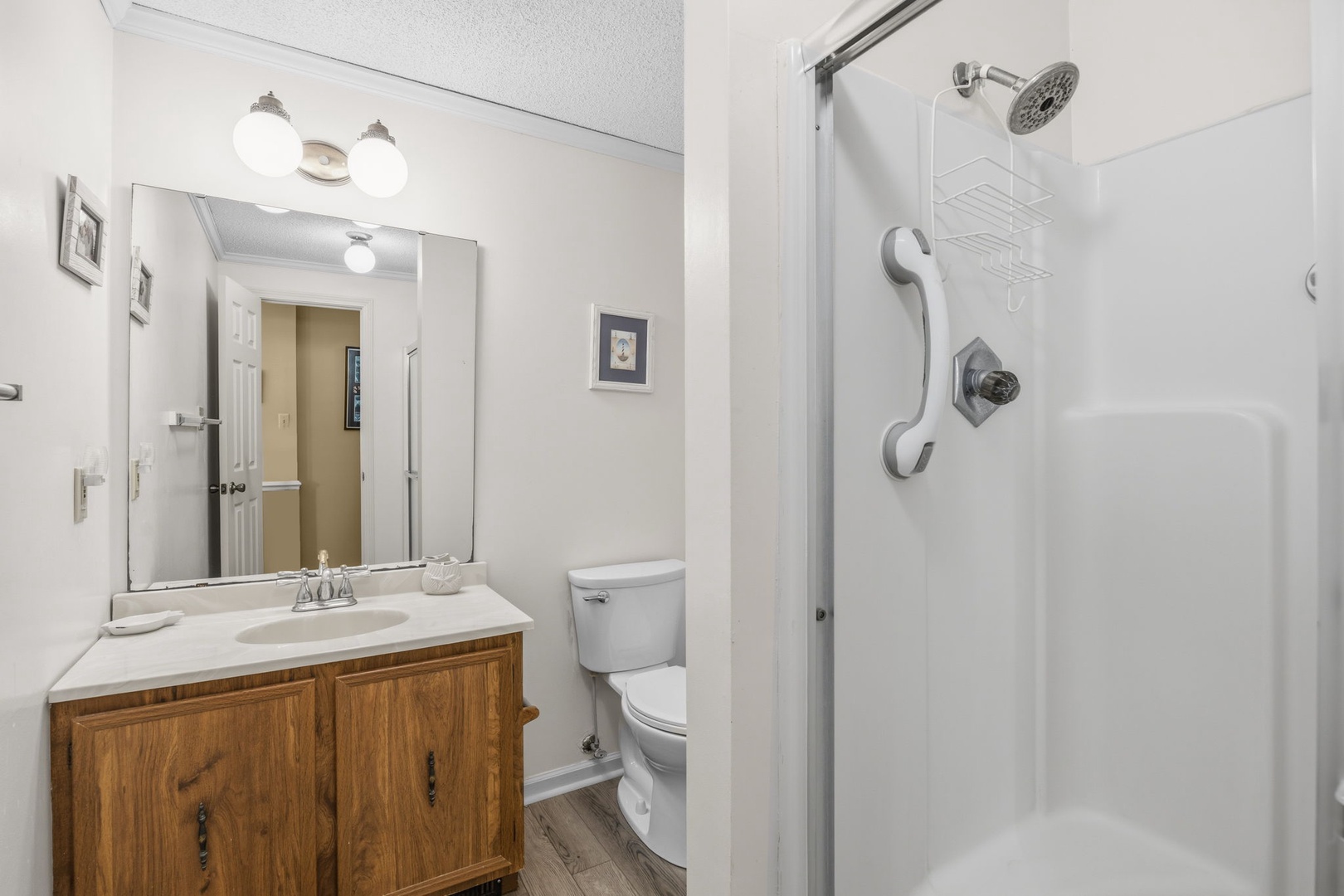 Your private bathroom features a spacious walk-in shower and warm wood vanity, creating a comfortable retreat for your stay.