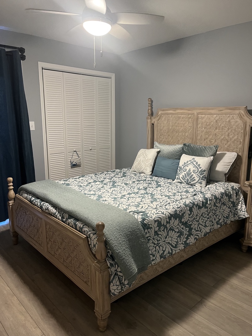 Sink into plush pillows and soft blue florals on your elegant bed, where coastal comfort meets refined style in your peaceful retreat.