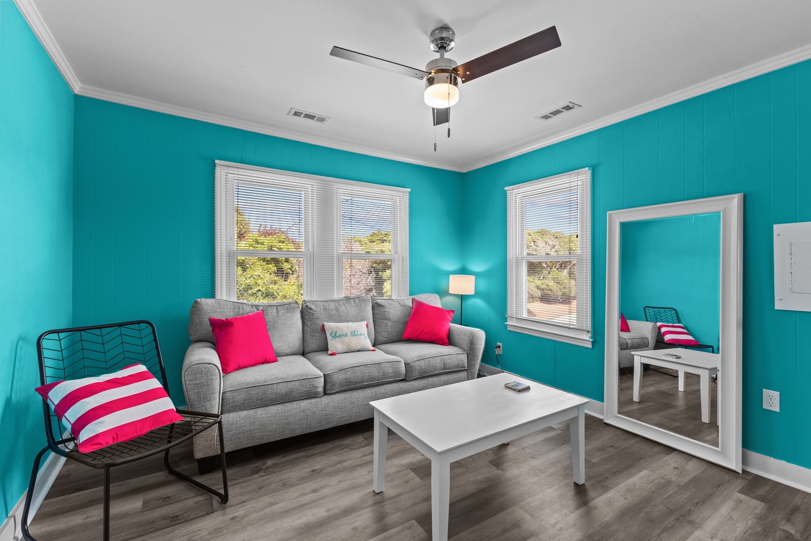 Relax in your vibrant living room with plush seating, natural light streaming through windows, and playful pops of color.