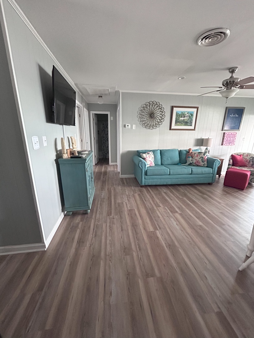 Unwind in your spacious living room with turquoise furnishings, cozy seating, and entertainment ready for your relaxation.