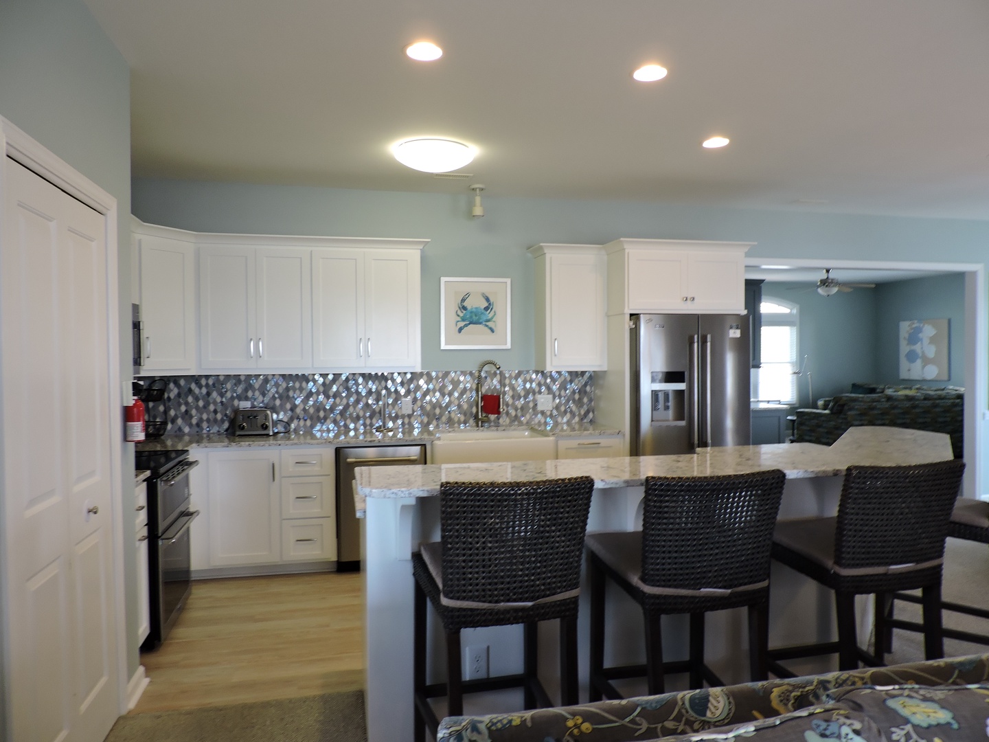 Step into your spacious kitchen featuring gleaming white cabinets, granite countertops, and a sparkling backsplash that catches the light beautifully.