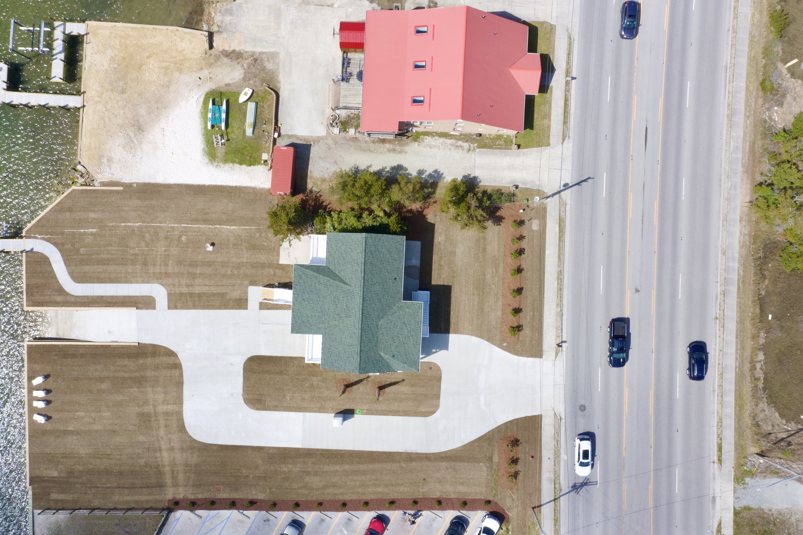 Aerial view of the property showing the main building with green roofing and surrounding area near the highway.
