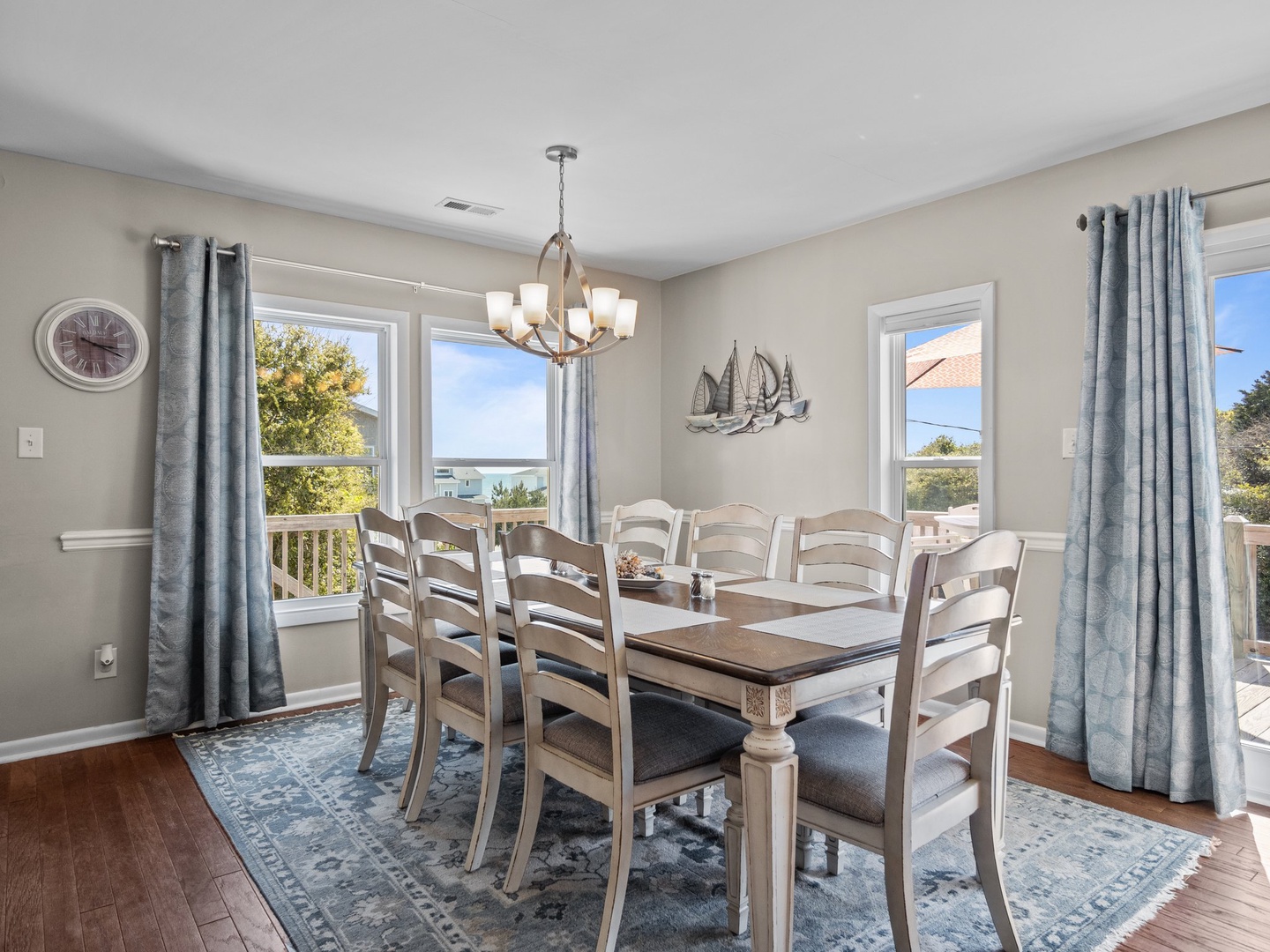 Gather around this elegant dining table for memorable meals with your group, enjoying beautiful natural light and coastal charm.