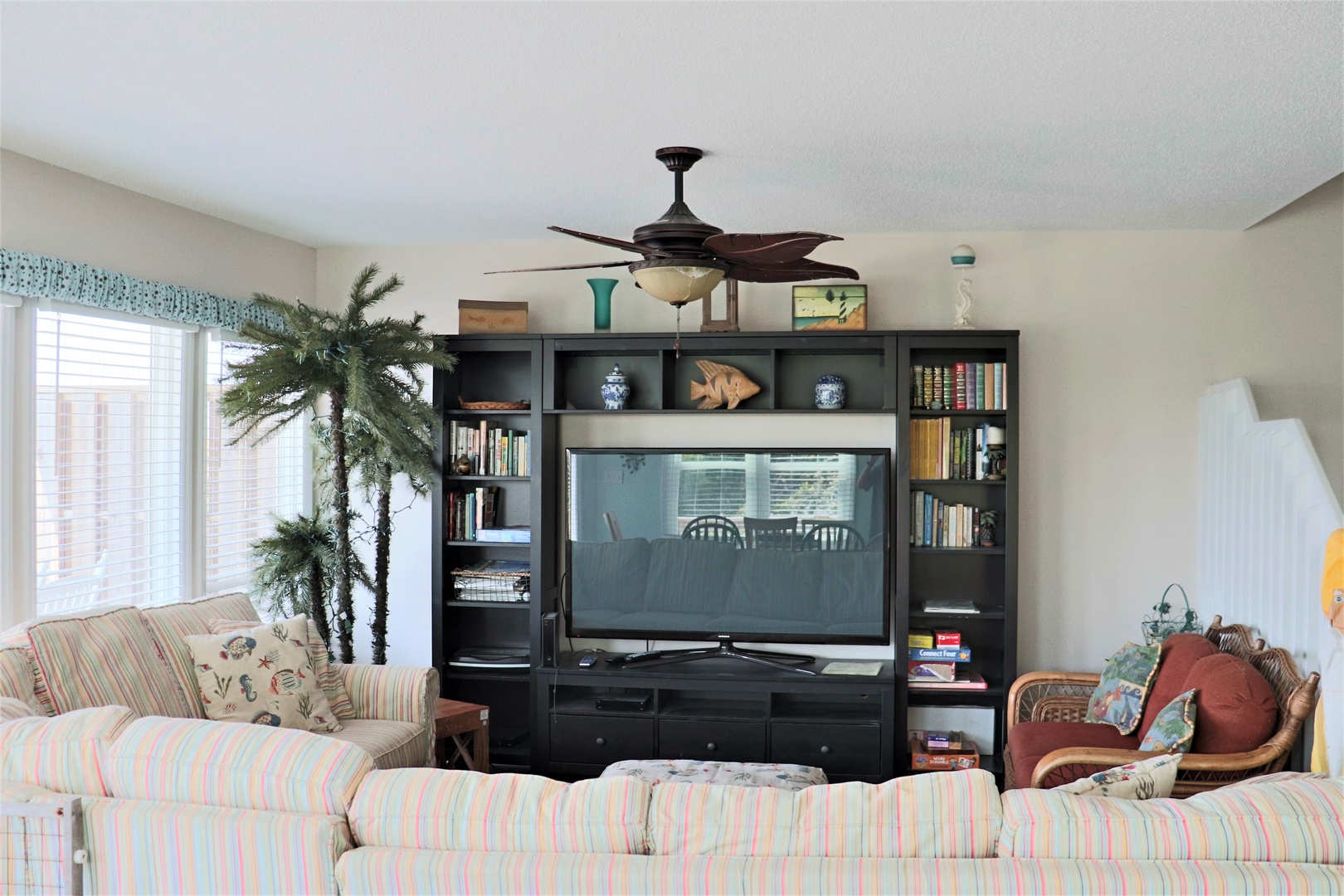 Unwind in your bright living room with comfortable seating, entertainment center, and tropical touches that create the perfect vacation atmosphere.