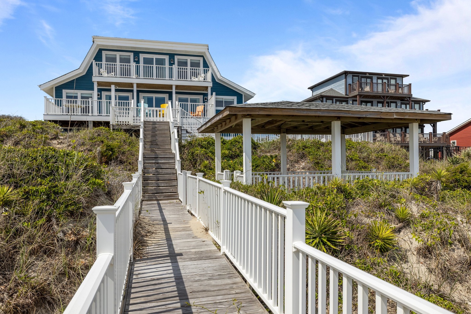 Charming coastal home elevated among dunes, with private boardwalk access through native vegetation.