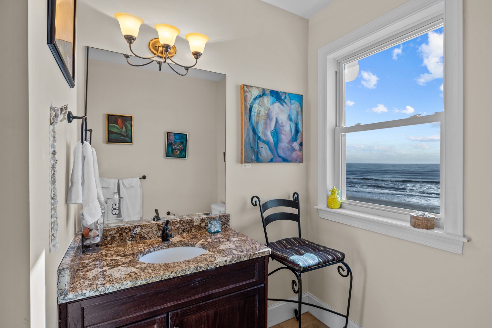Freshen up in your stylish bathroom while enjoying breathtaking ocean views through the window—pure coastal luxury.