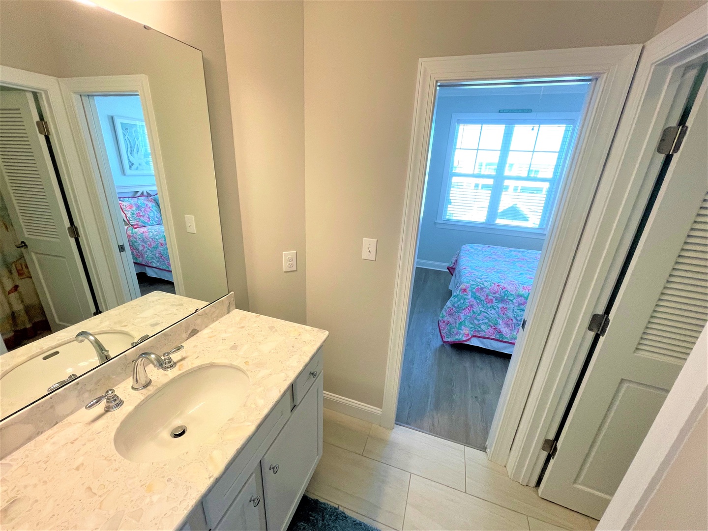 Your bright bathroom features marble countertops and connects seamlessly to cozy bedrooms with charming coastal views.
