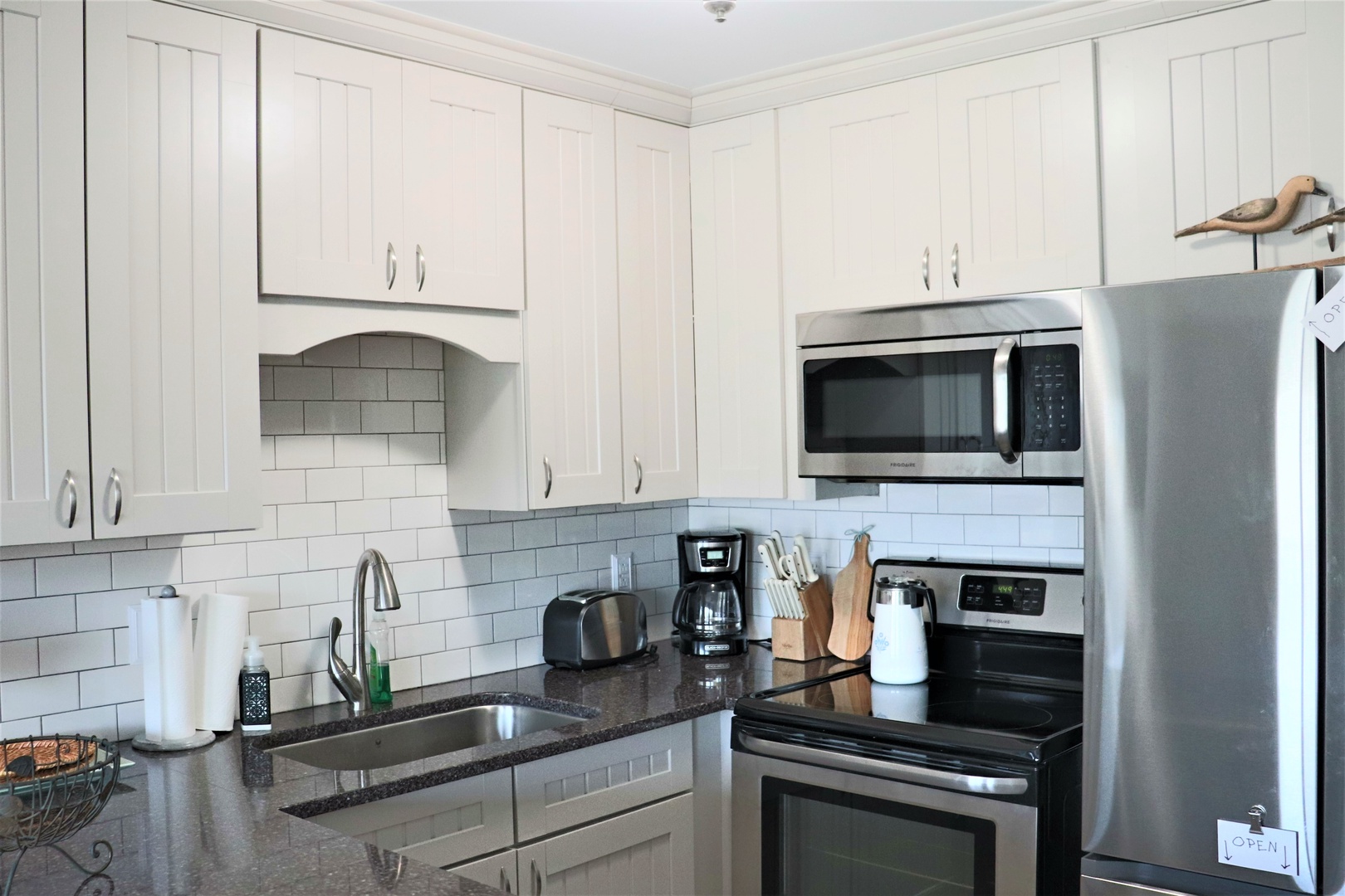 Your modern kitchen awaits with gleaming stainless steel appliances and pristine white cabinetry, perfect for preparing memorable meals together.