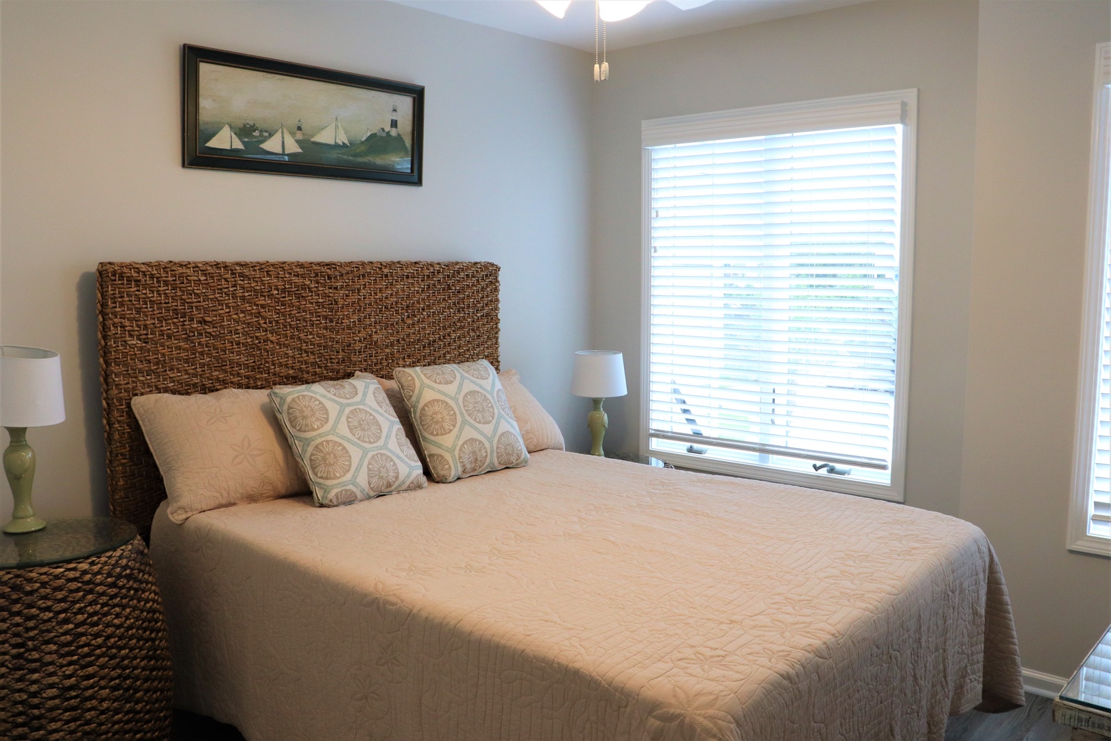 Sink into the plush bedding while coastal charm surrounds you in this serene bedroom retreat.