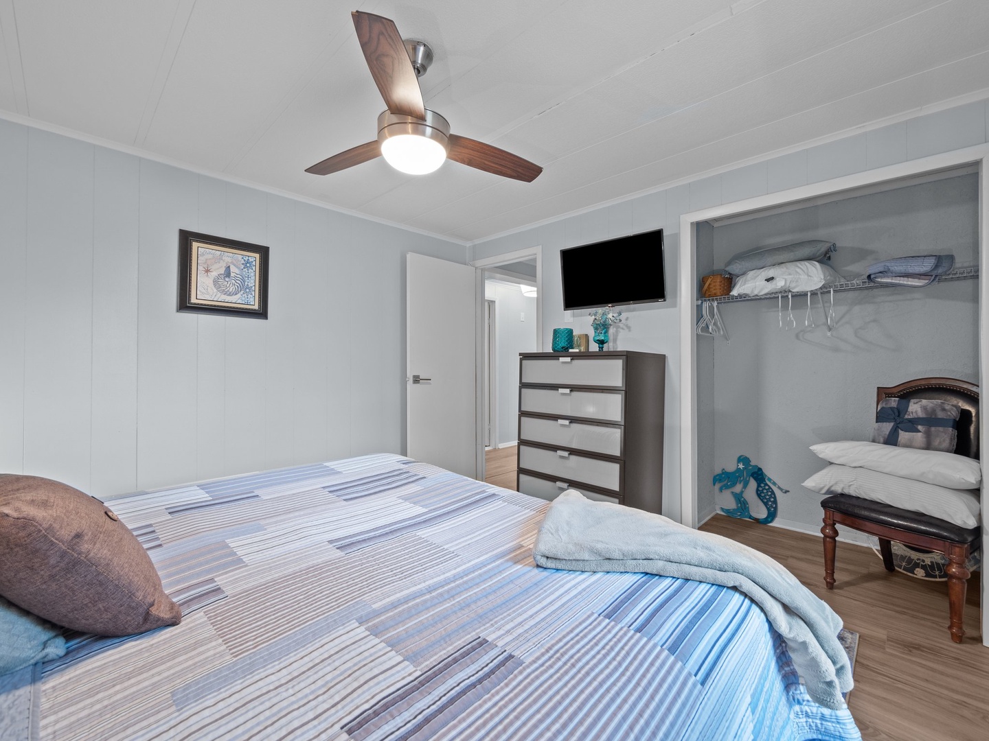 Unwind in your comfortable bedroom with ceiling fan, flat-screen TV, and thoughtful storage solutions keeping everything organized for your stay.