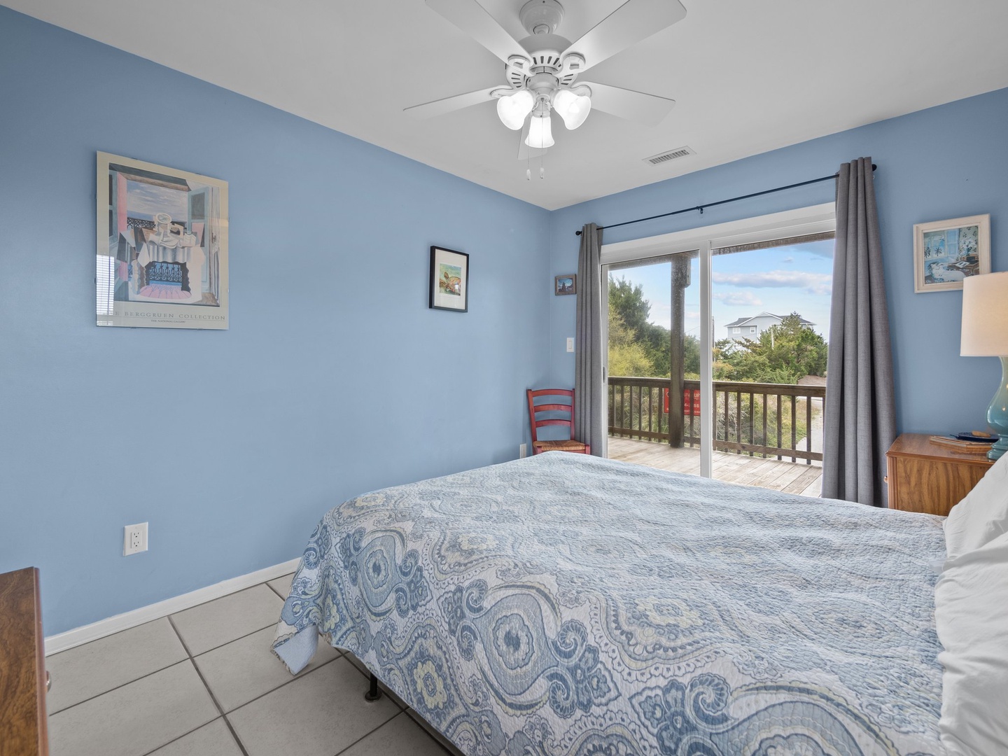 Your peaceful bedroom features soothing blue walls and opens to a private balcony where you can enjoy morning coffee surrounded by trees.