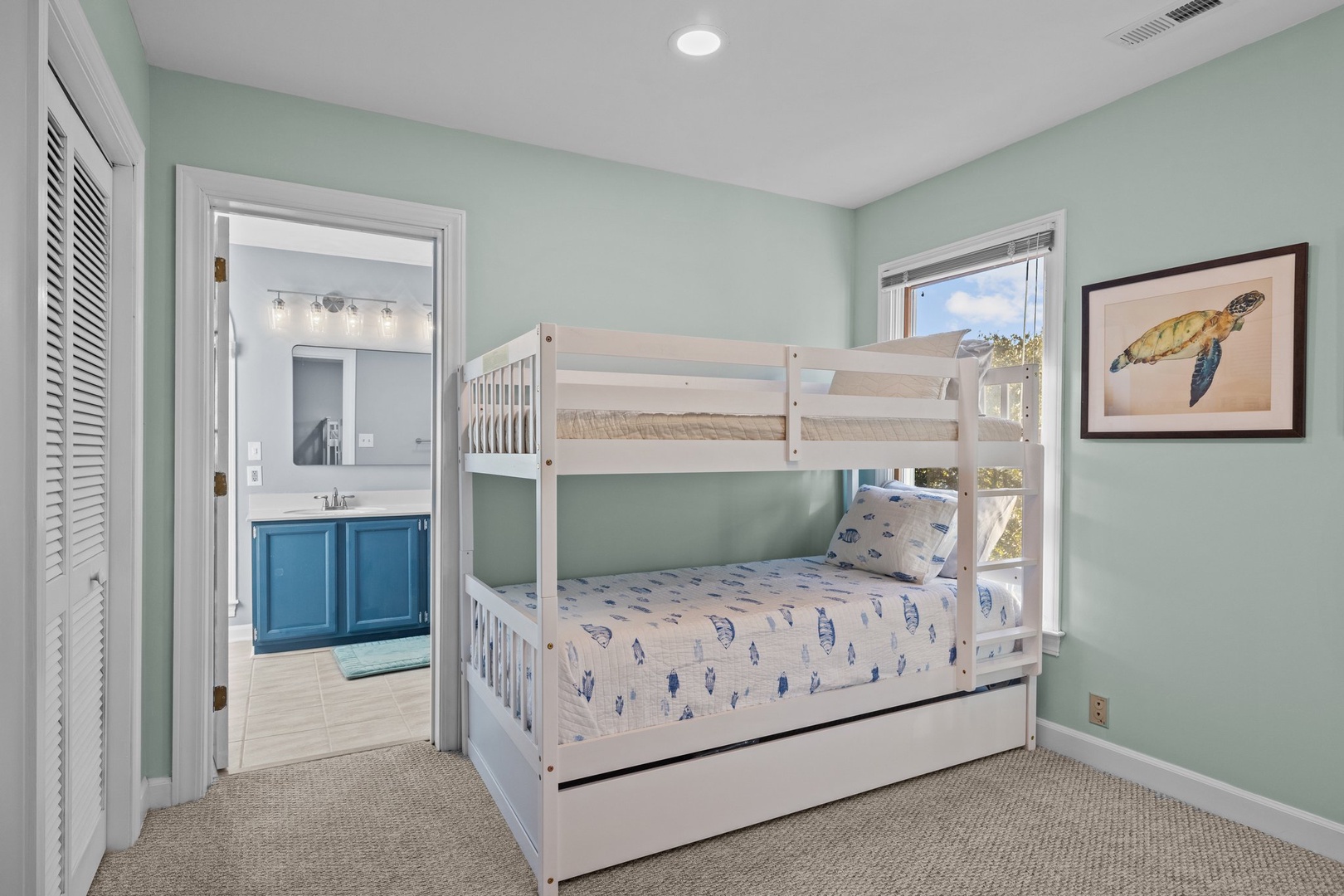Your kids will love this ocean-themed bunk room with sea turtle art and a trundle bed for extra friends.