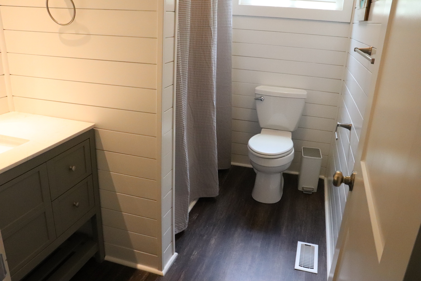 Your private bathroom features charming shiplap walls, a spacious vanity with storage, and modern fixtures for your comfort.