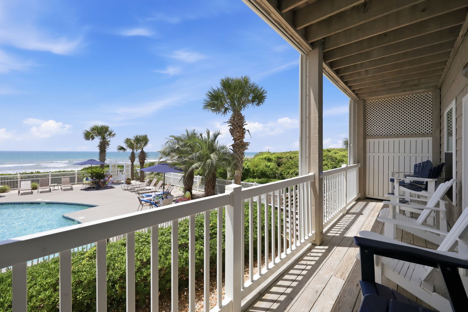 This covered balcony overlooks a sparkling pool, swaying palms, and the ocean just beyond—your perfect spot to unwind with morning coffee or evening sunsets.