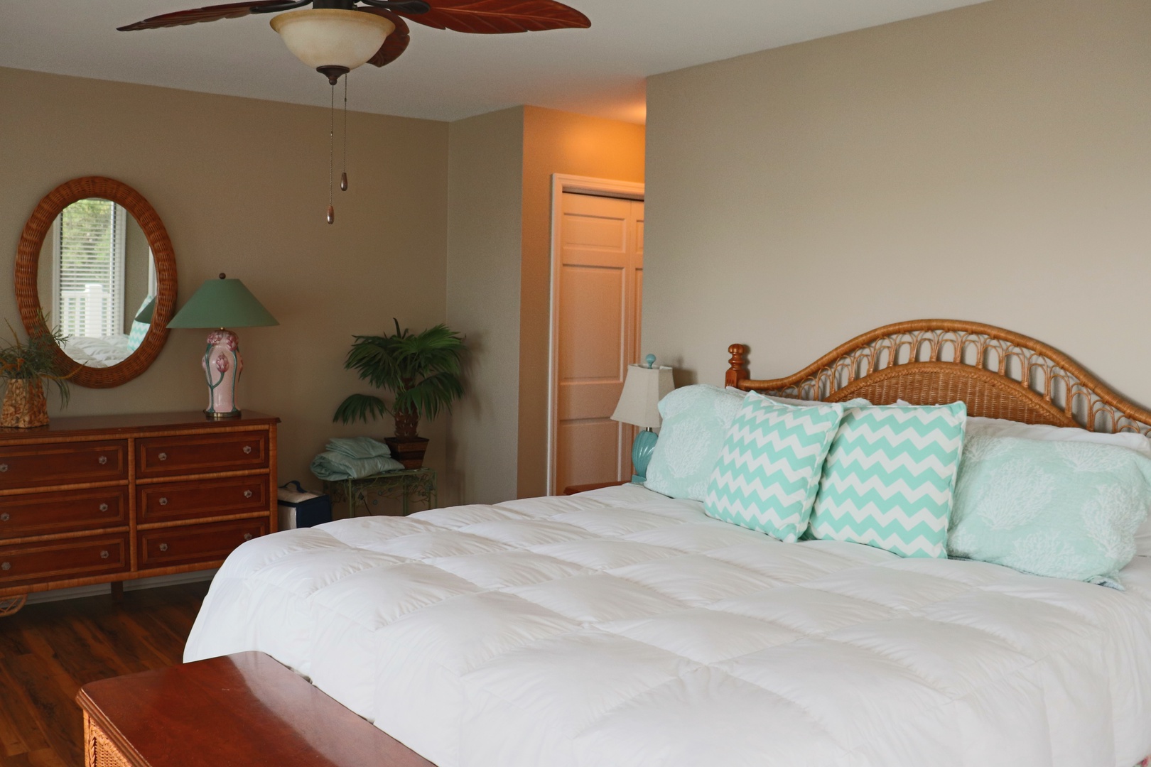 Drift off in this peaceful bedroom featuring tropical-style furnishings, crisp linens, and cheerful aqua accents that create your perfect coastal retreat.