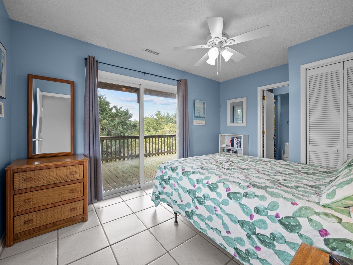 Drift off in this peaceful blue bedroom where natural light streams through sliding doors to your private balcony overlooking lush greenery.