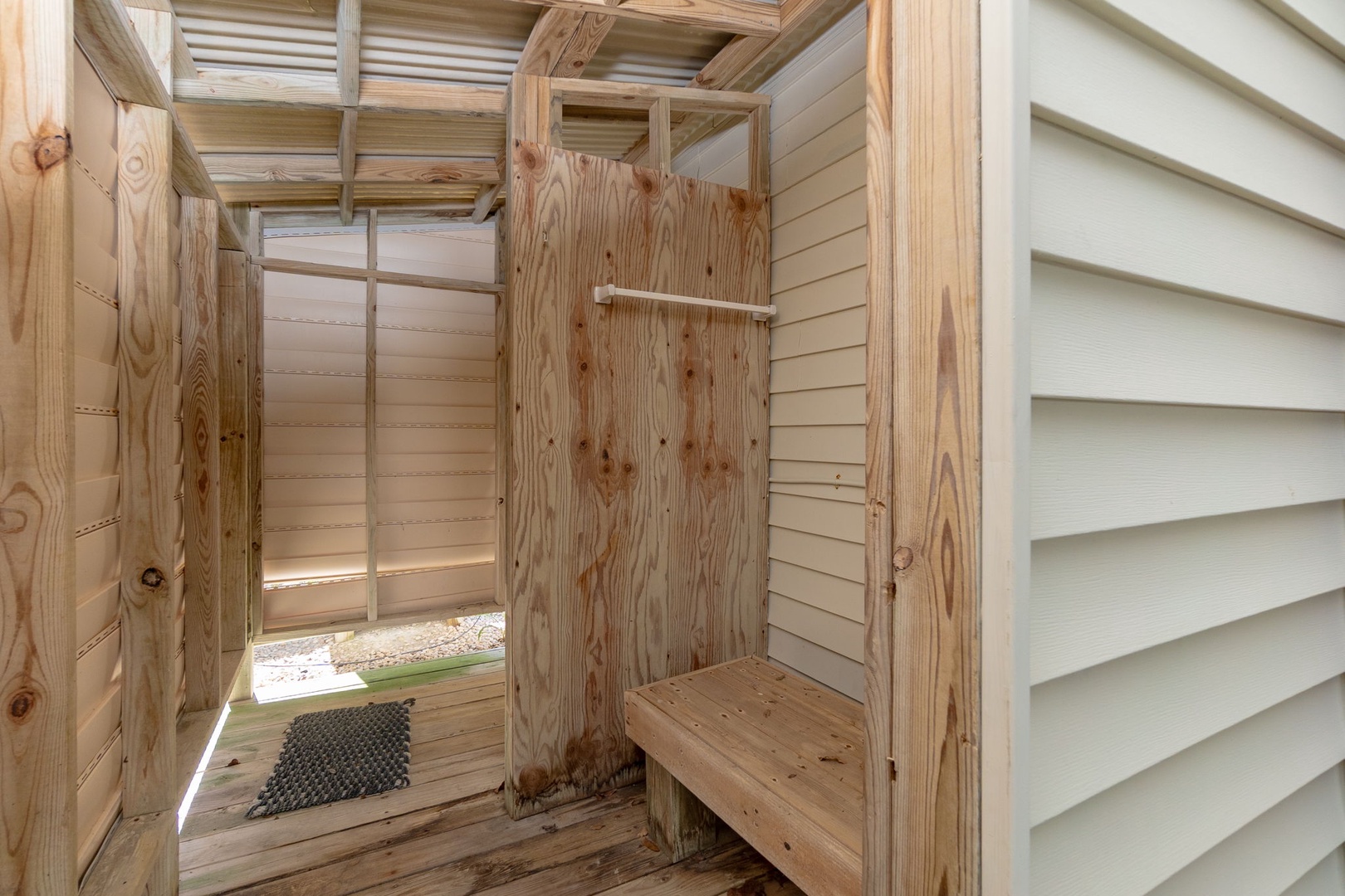 Step into your private outdoor shower, where natural wood meets refreshing open-air bathing for a unique coastal experience.