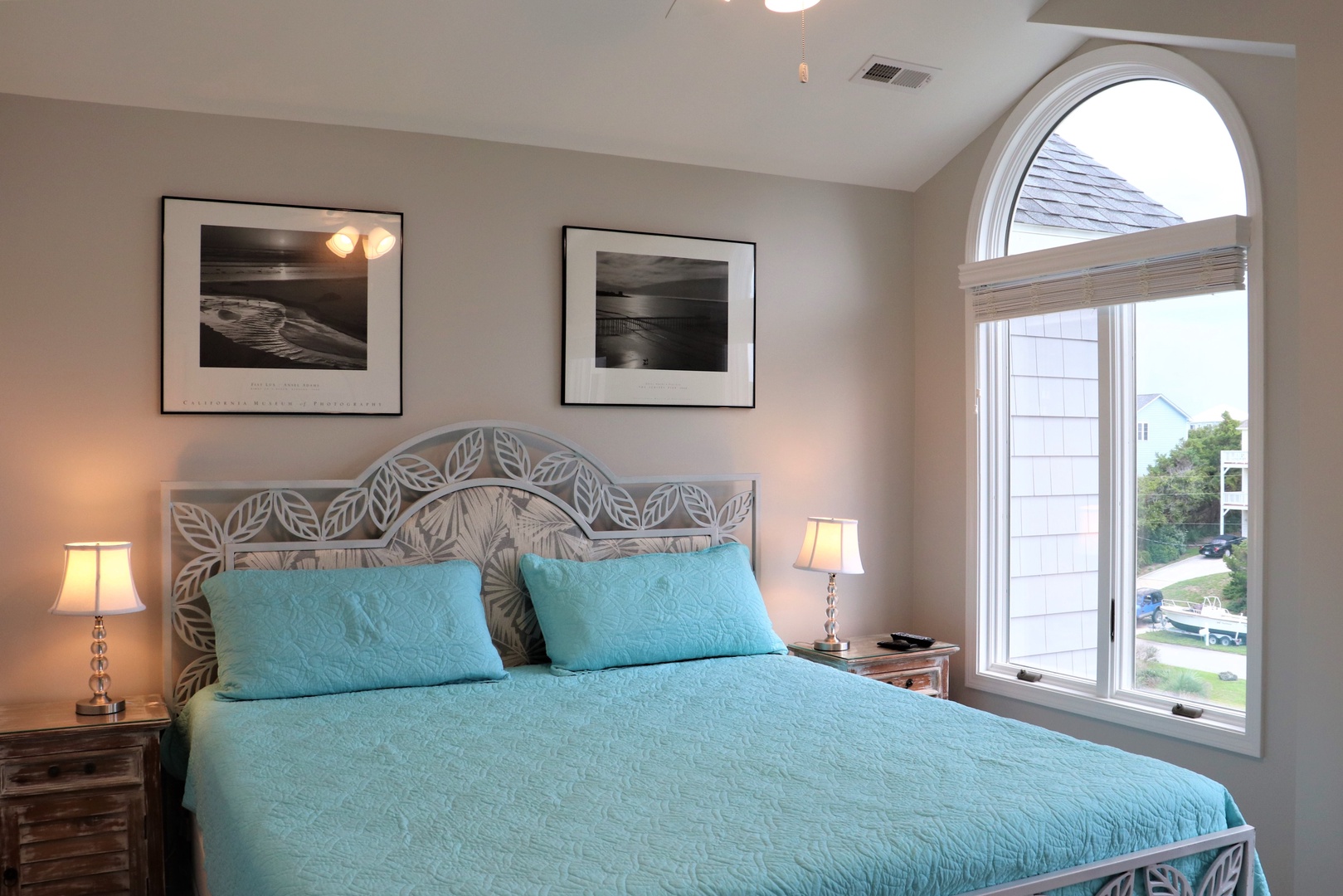 Wake up in your bright bedroom with its elegant arched window, soft lighting, and coastal-inspired decor creating the perfect peaceful retreat.