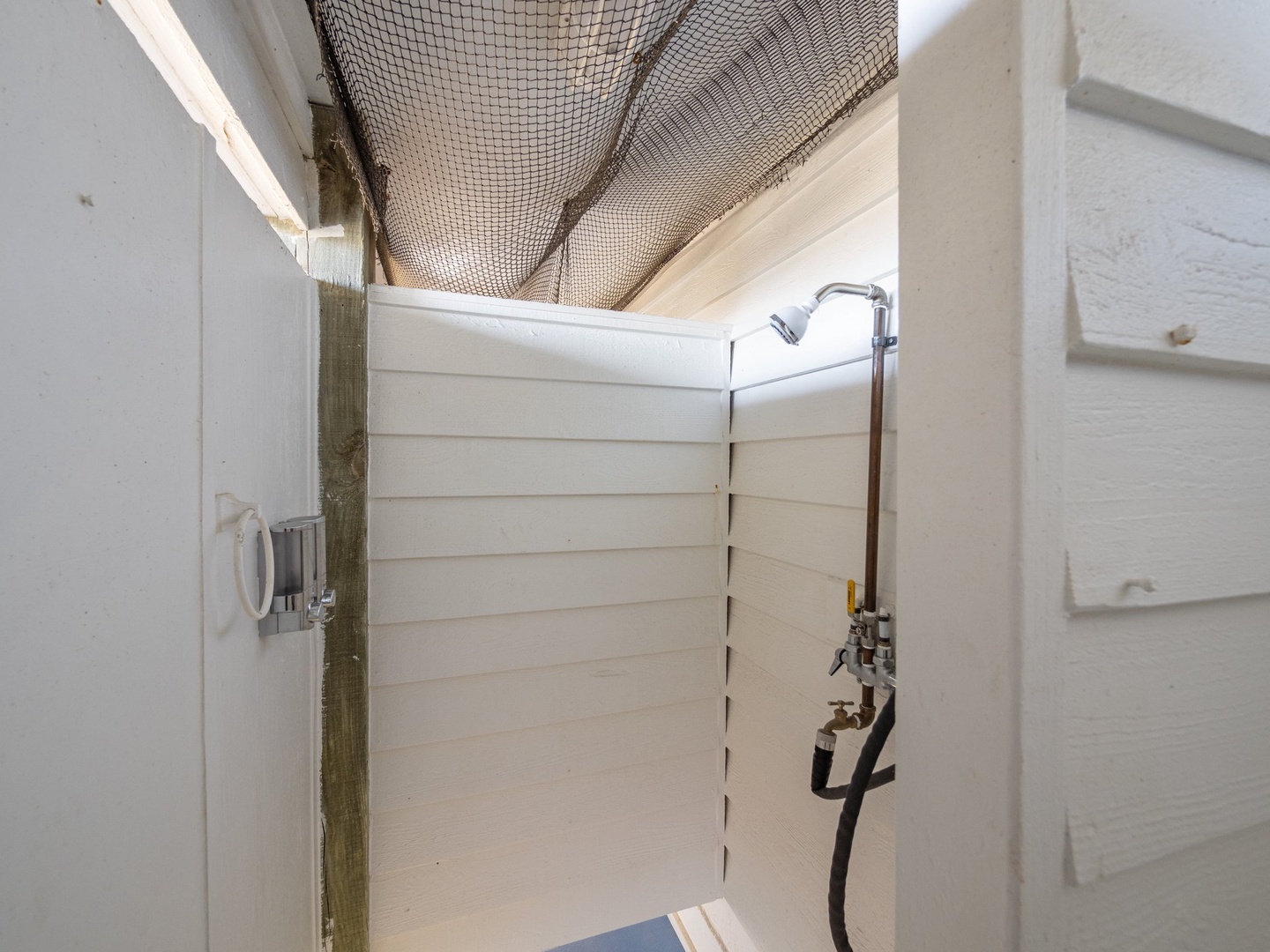 Rinse off after beach adventures in your private outdoor shower, surrounded by natural netting for complete seclusion.