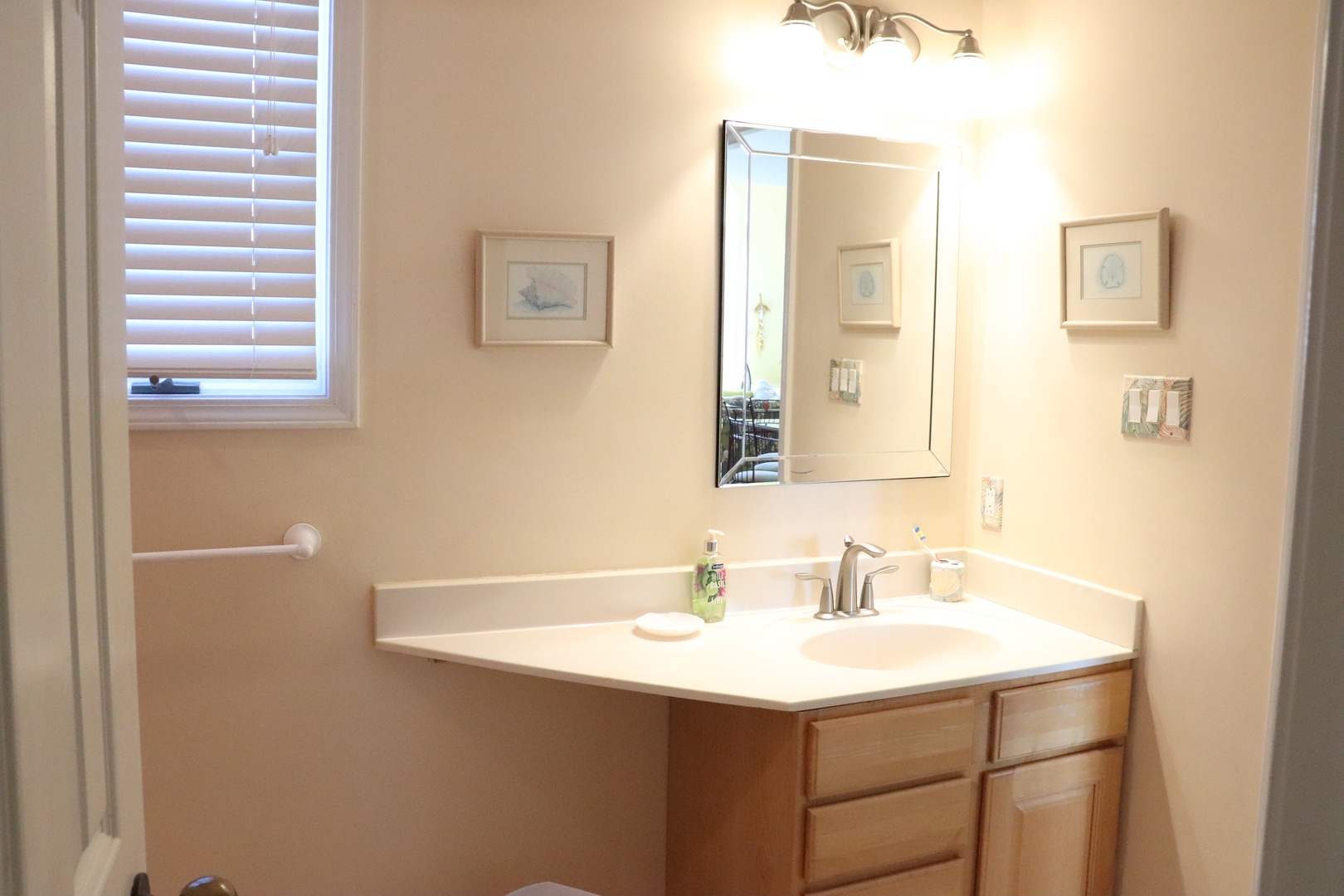 Your private bathroom features a spacious vanity with warm wood cabinets, perfect lighting, and thoughtful amenities for your comfort.