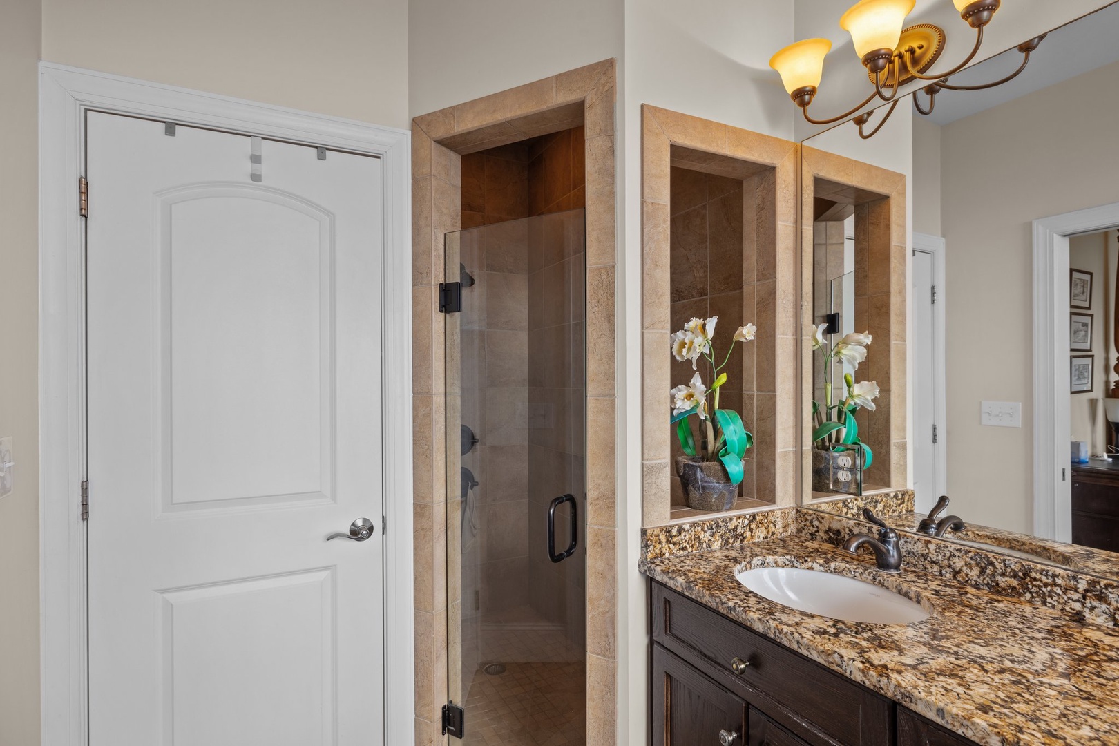 Step into your elegant bathroom sanctuary with granite countertops, walk-in shower, and thoughtful orchid touches creating a spa-like retreat.