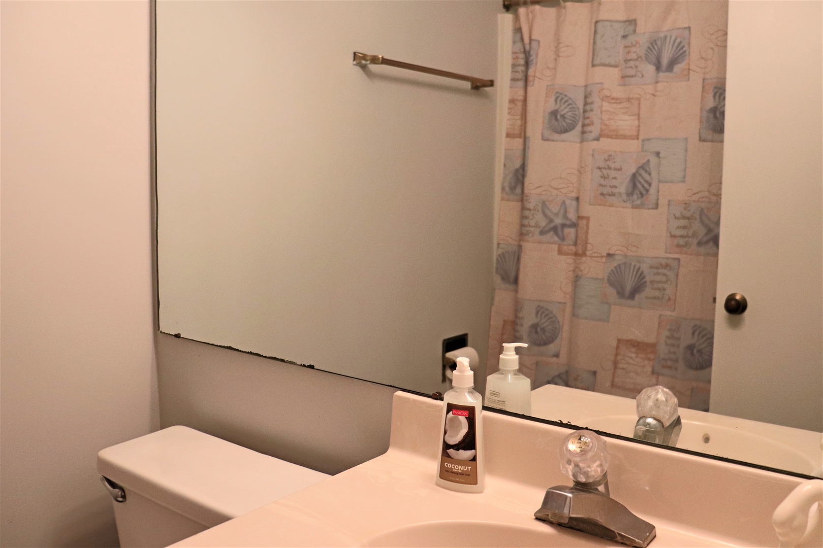 Your private bathroom features thoughtful amenities and coastal-themed decor, creating a serene space to refresh during your stay.