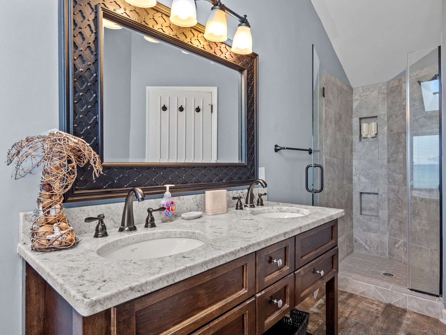 Unwind in your elegant bathroom featuring dual vanities, granite counters, and a luxurious walk-in shower with marble-style tiling.