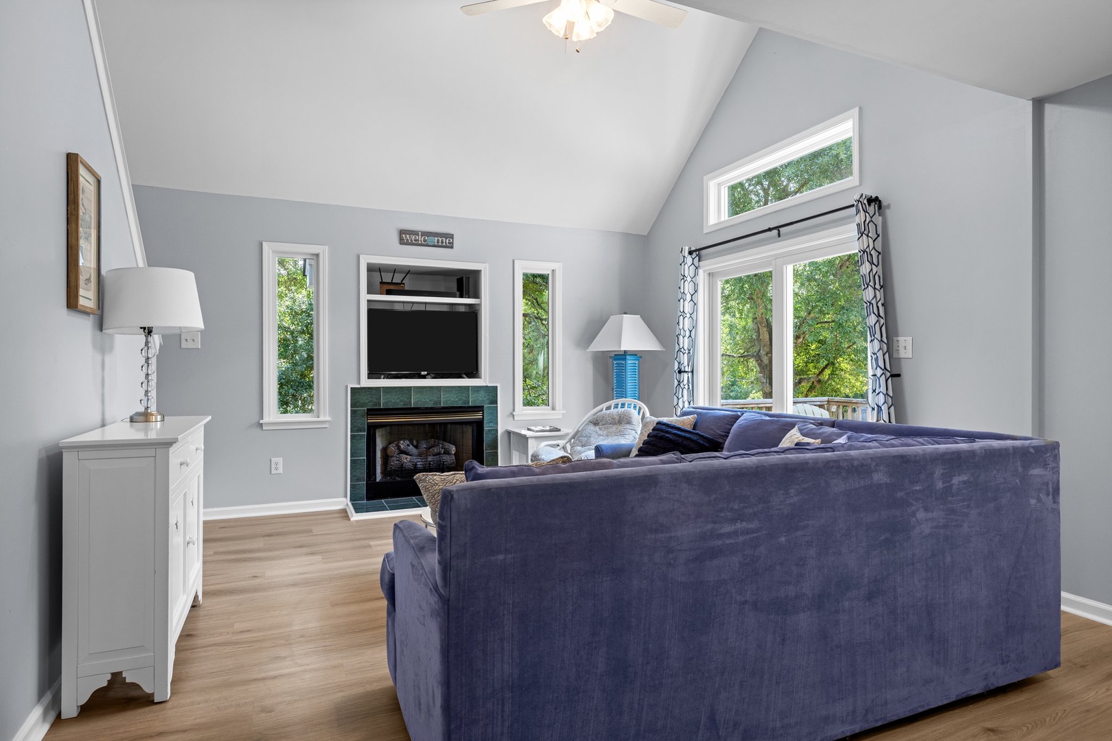 Unwind in your bright living space with soaring vaulted ceilings, cozy fireplace, and plush seating that invites relaxation.